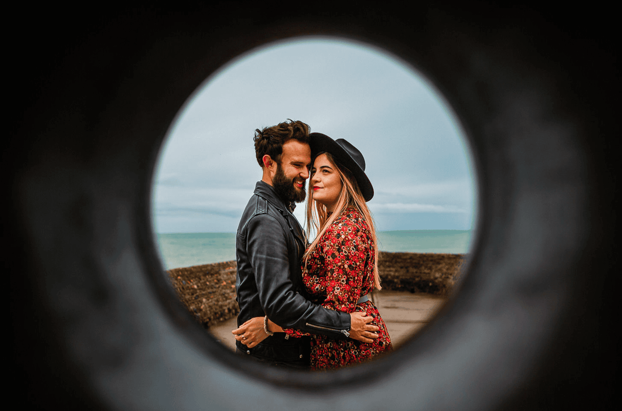 James bond barrel shot of couple on pier