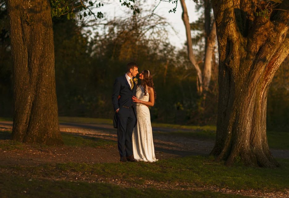 Bride and groom in elegant attire outside Penton Park mansion