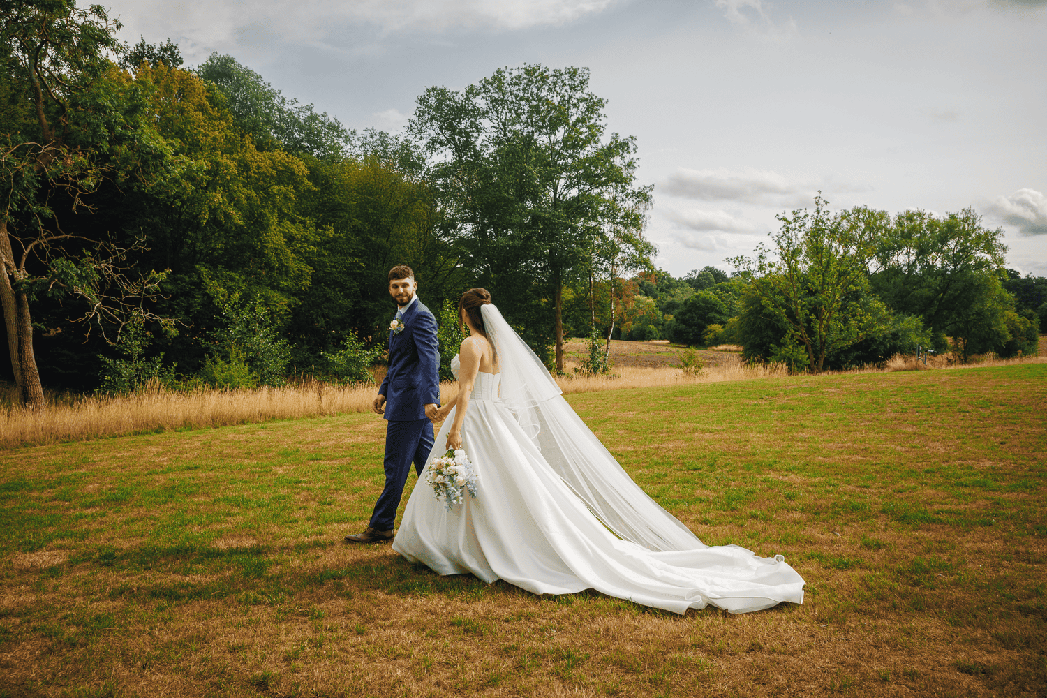 Newlywed couple walking away hand in hand at Brook Farm