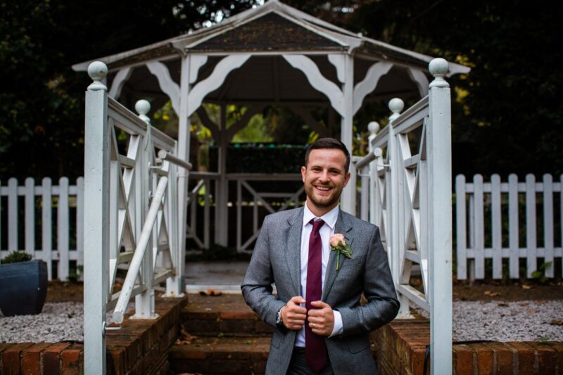 Groom in light grey casual suit at outdoor wedding