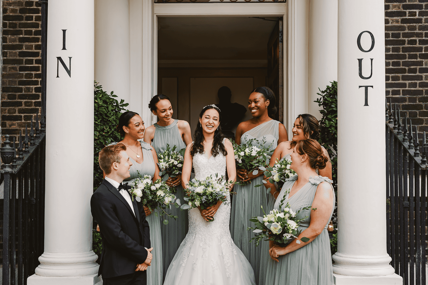 Bride being helped downstairs at The In and Out Club during preparations