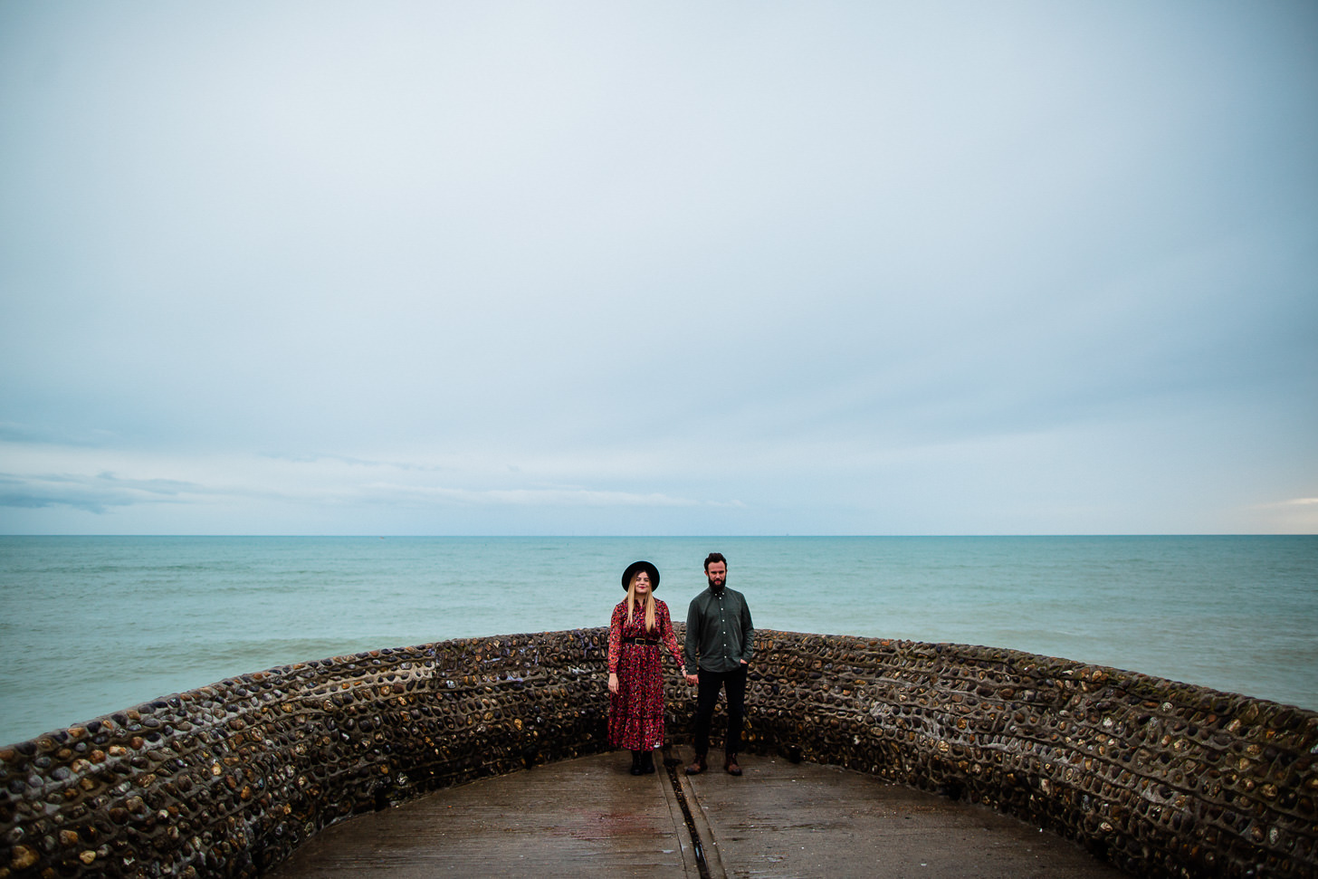 Couple laughing together in coordinated outfits at Brighton engagement shoot